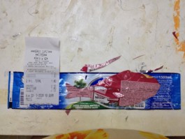  Collage de Odalys Orozco con recortes de papeles de gaseosas y el recibo en forma de ballena colores azul de fondo y ballena rojiza